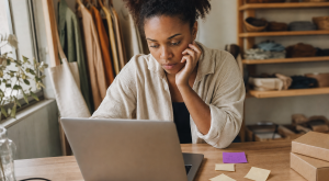 lojista comparando opções no notebook para entender como escolher um CRM para a sua loja virtual