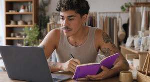 lojista organizando o relacionamento com clientes usando CRM para Nuvemshop em um caderno e no notebook